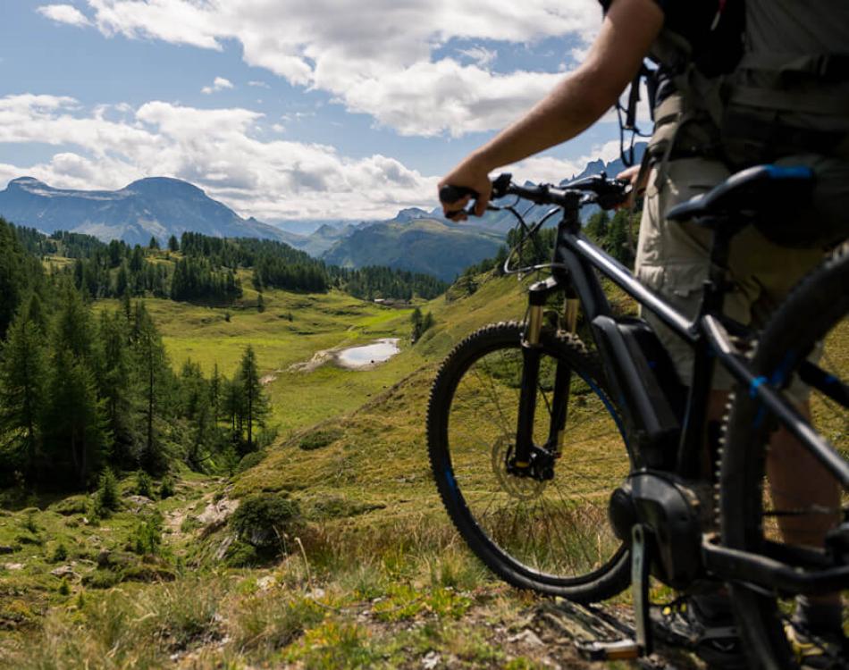 Cyclist on a mountain trail with a panoramic view.