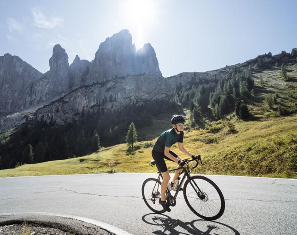 Person biking among white flowers under a blue sky.